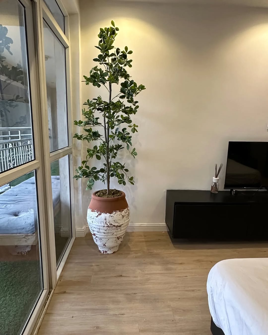 A tall artificial planter with pot in a modern living room