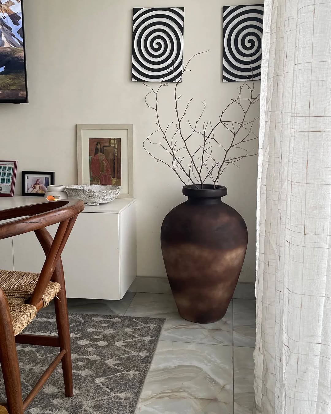 Smoked Brown Onasis planter styled with twigs in a minimalist living room corner, adding earthy elegance and natural warmth to modern interior décor.