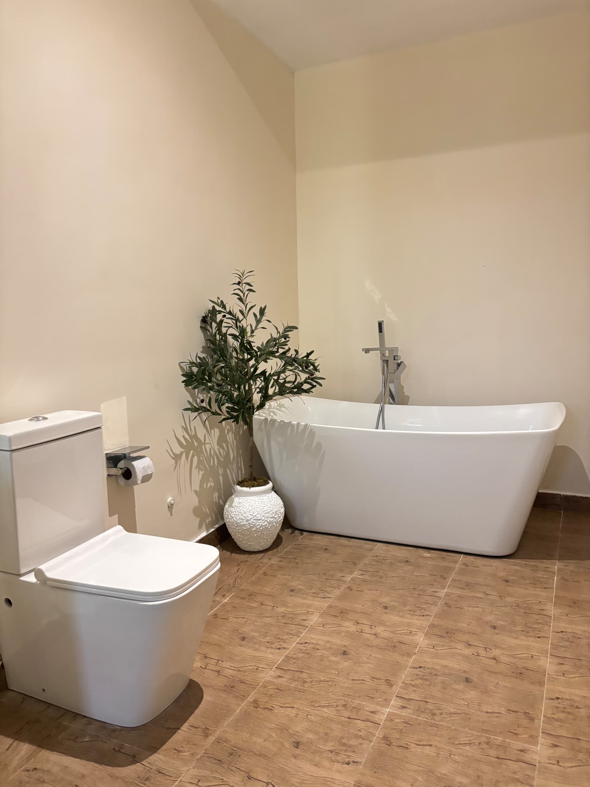 Small sandblast flower pots styled with a lush artificial olive tree, placed against a clean neutral background for a minimalist interior look.Oriental Effect.”
