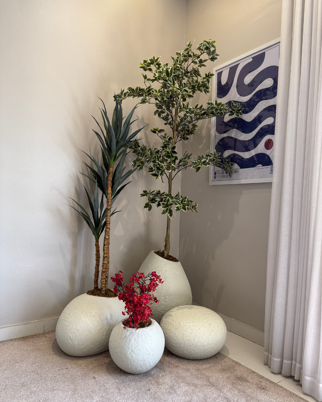 Indoor plant arrangement featuring neutral decorative planters in rustic grey, off-white, beige, and matte black paired with artificial olive trees, bamboo trees, traveller palms, and ficus trees for elegant modern interiors.