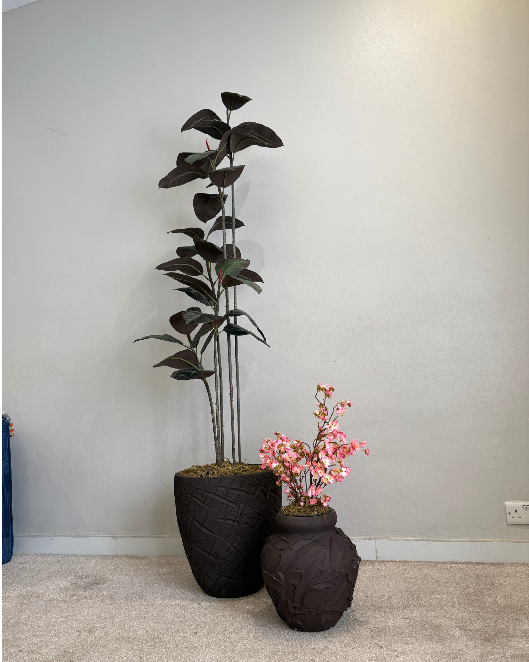 Indoor plant arrangement featuring earth-toned decorative planters in terracotta, brown wash, and mocha white paired with premium artificial plants, adding warmth and elegance to living rooms, patios, and hospitality spaces.