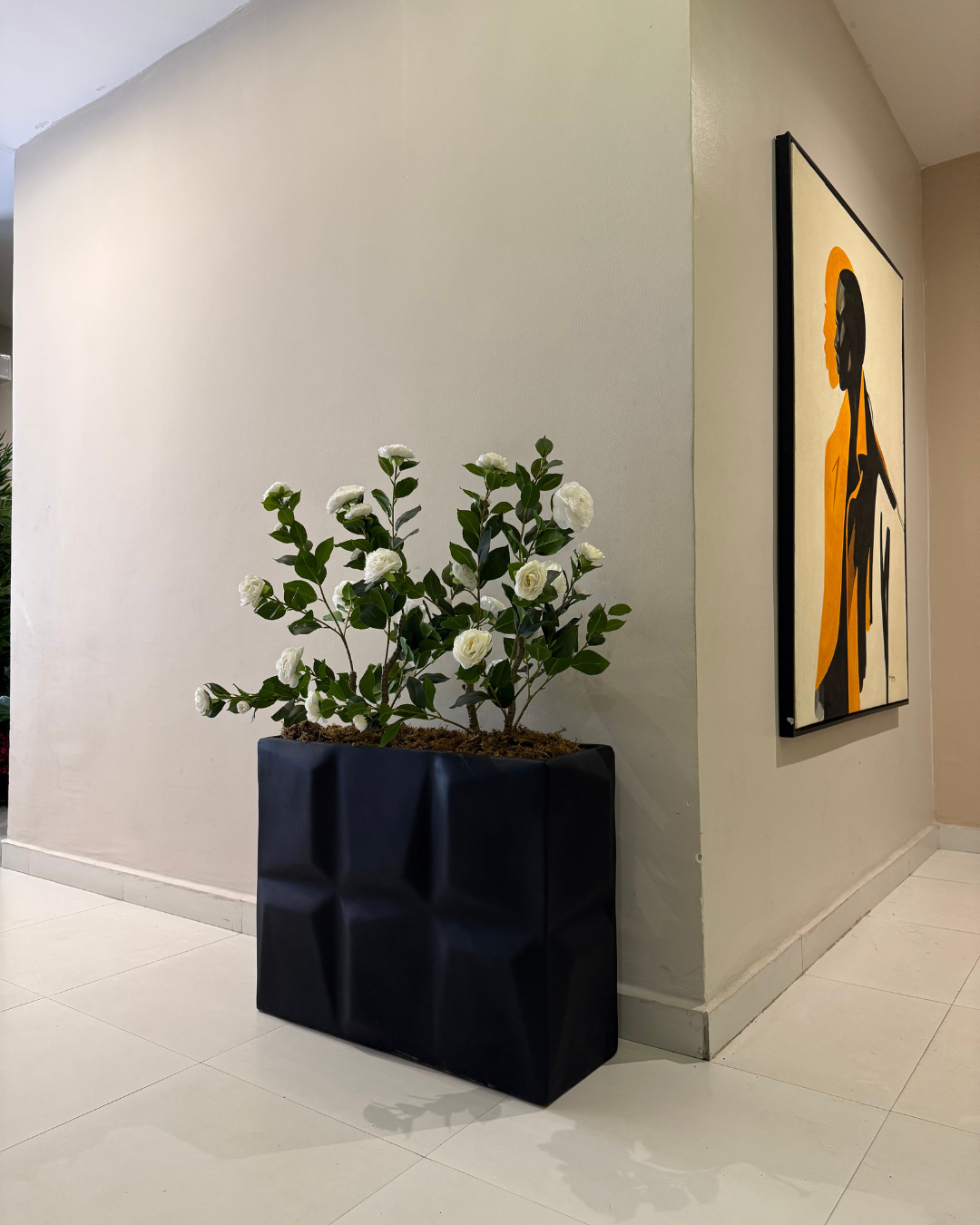Indoor planters featuring a matte black Big Prism pot styled with double artificial camellia trees, creating a bold and elegant statement for modern homes, offices, and commercial interiors.
